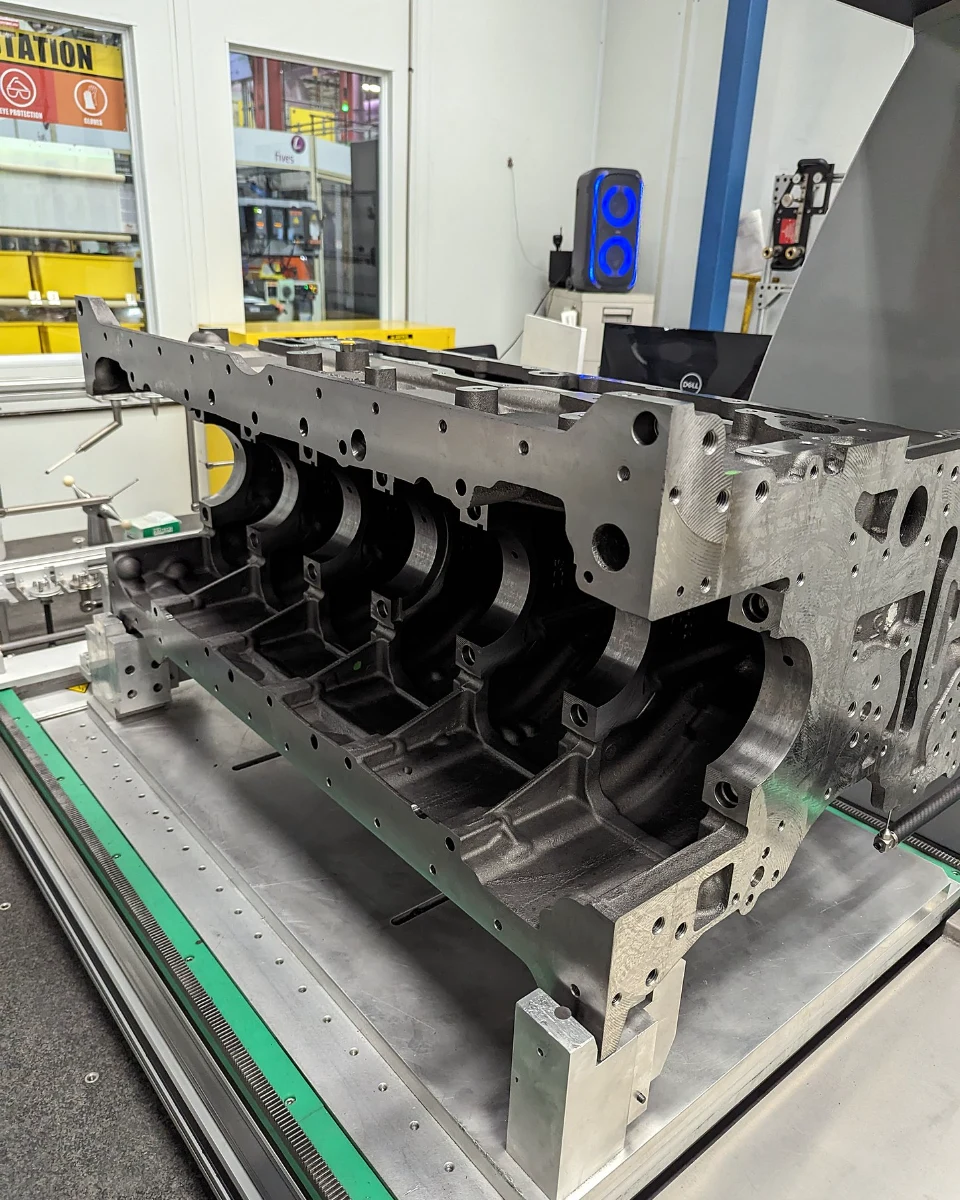 Engine block casting fixtured on a coordinate measuring machine table for inspection